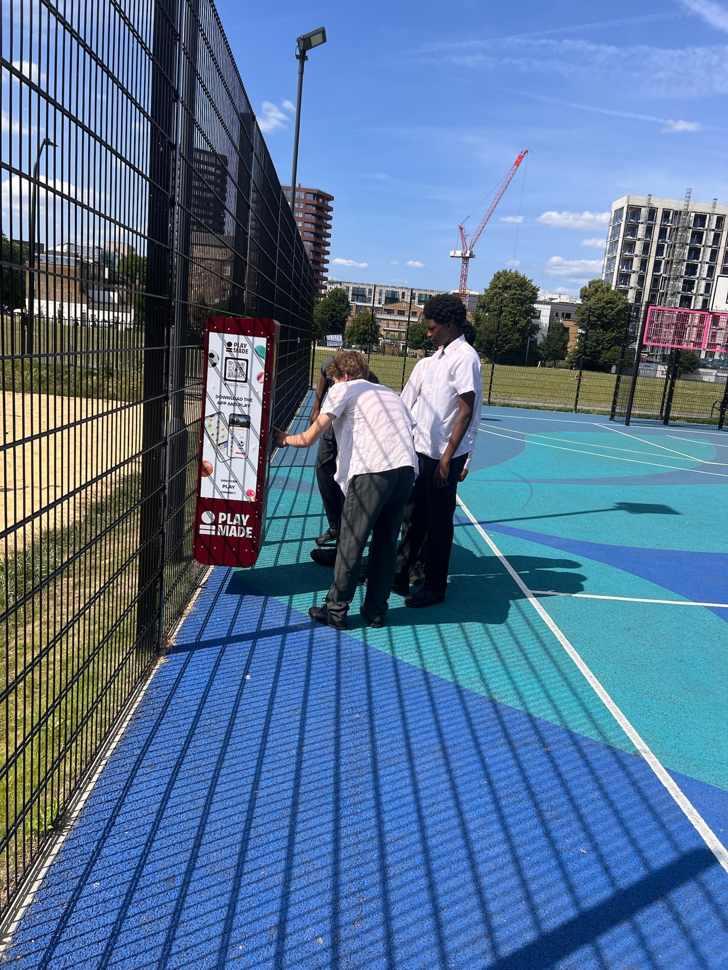 Teenagers using a PlayMade equipment station on a court